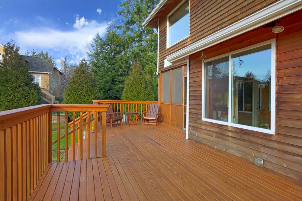 Back of the house with a wooden deck Backyard view of a Colorado home with a newly stained wood deck and outdoor seating area.