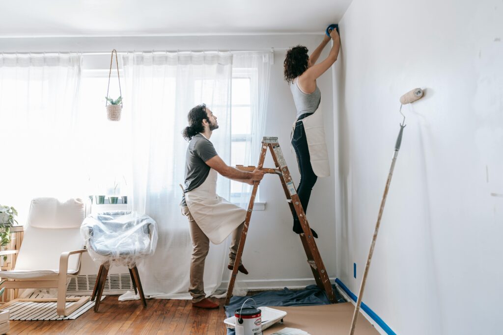 Person holding a ladder for another person during indoor renovations.