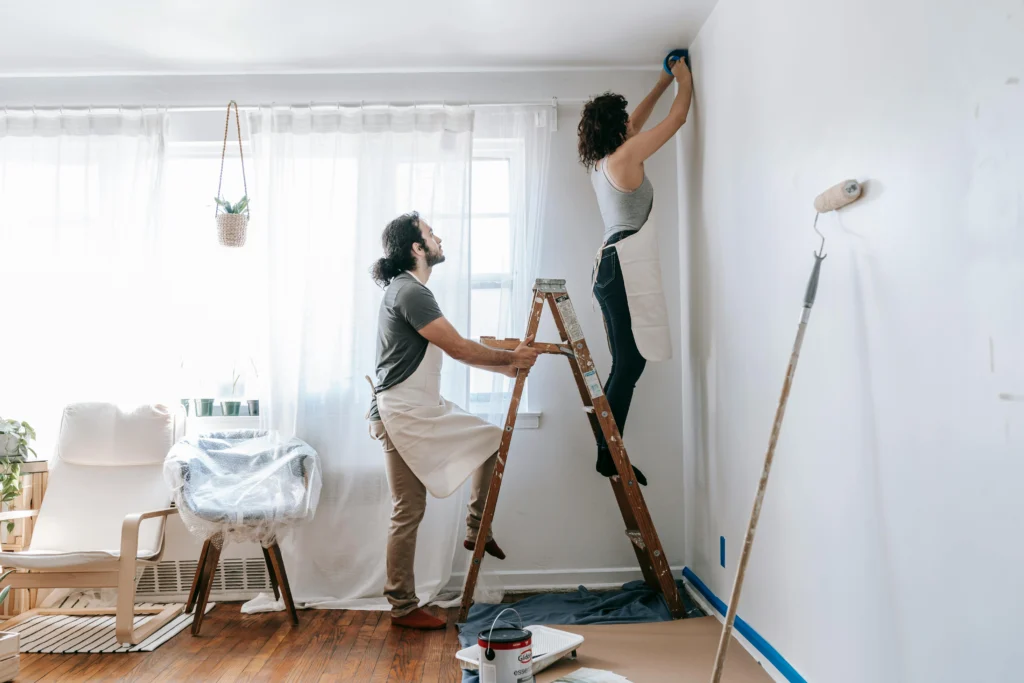 Person holding a ladder for another person during indoor renovations.
