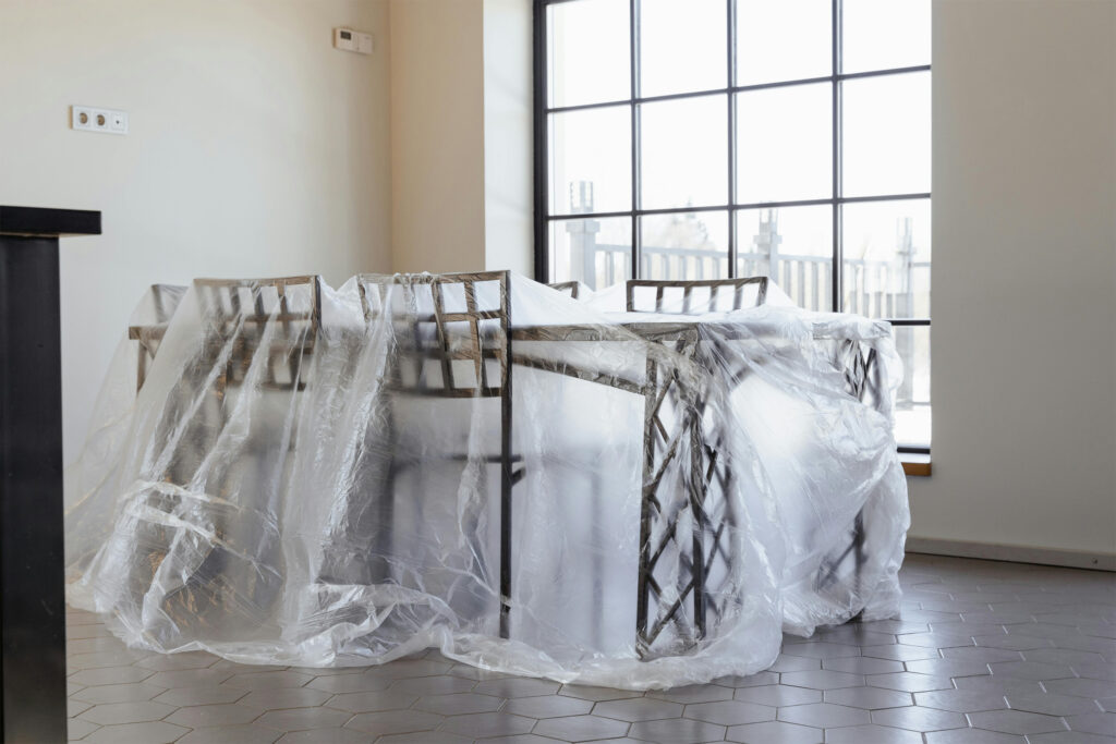 Plastic sheeting covering a table to protect it from home repairs like painting.