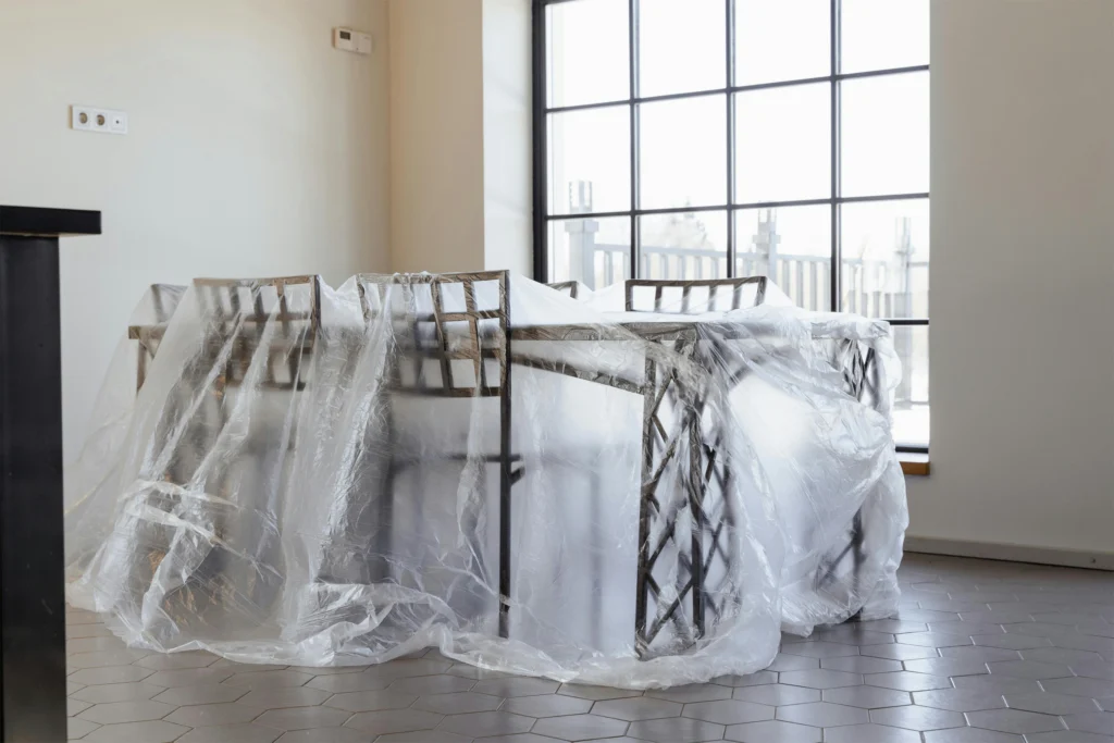 Plastic sheeting covering a table to protect it from home repairs like painting.